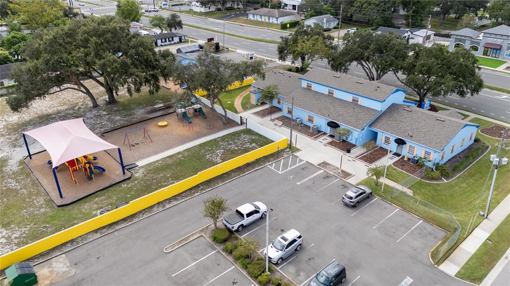 An aerial view shows a blue building with a playground and a parking lot — 217 N KIRKMAN ROAD, ORLANDO, FL