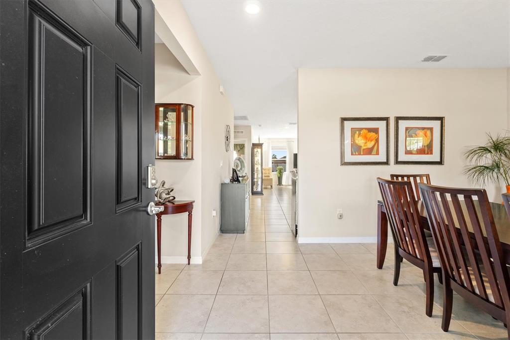 A view from an open front door into a tiled dining area and hallway — 1 FRENORA LANE, PALM COAST, FL