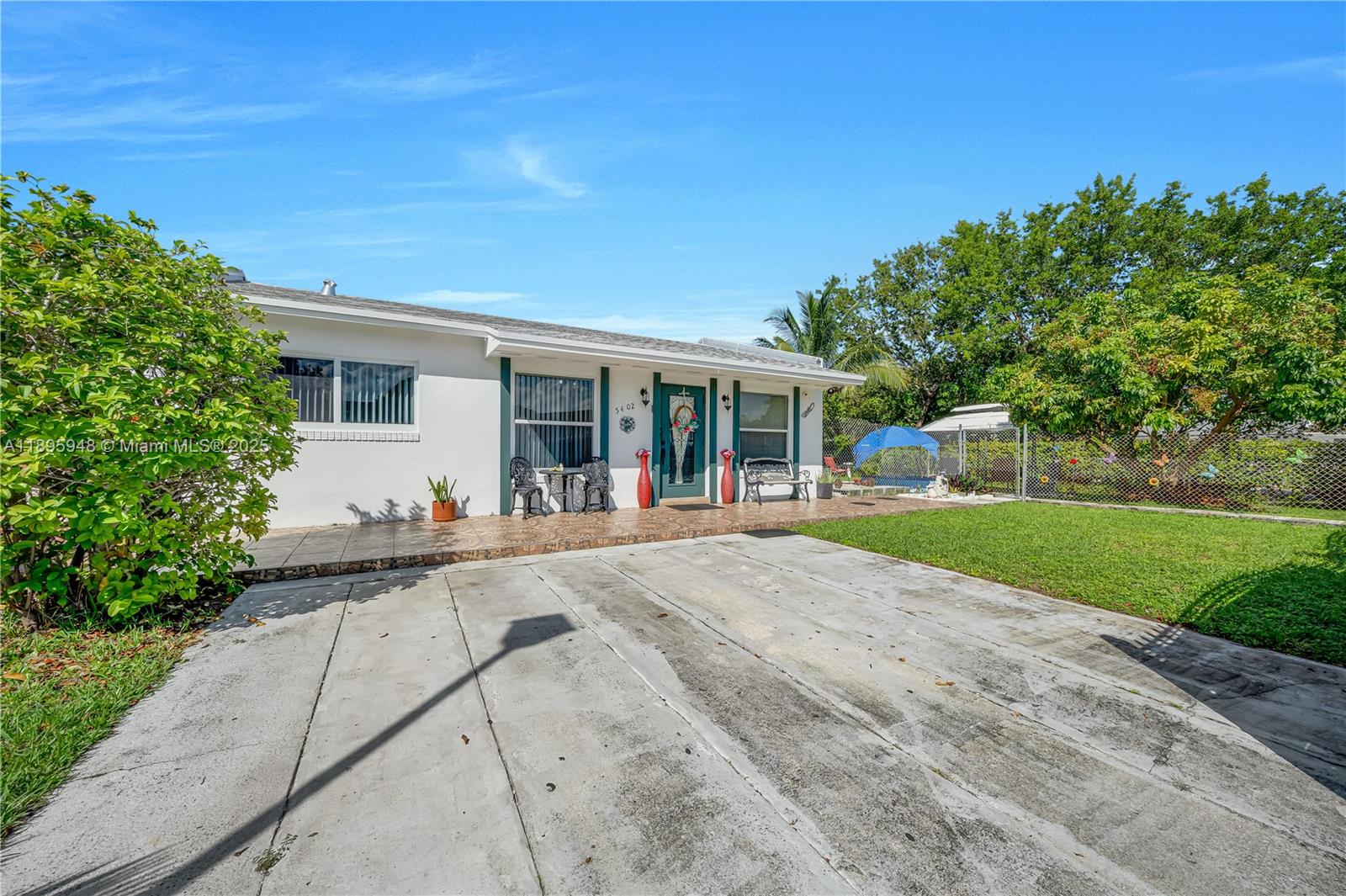 A single-story house with a white exterior, green trim, and a concrete driveway — 5402 SW 128th Pl, Miami FL 33175, MIAMI, FL