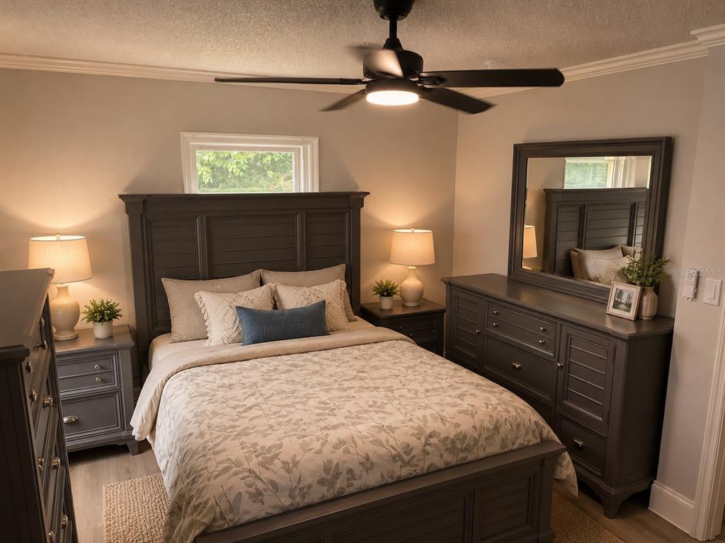 A bedroom features a dark gray bed frame, matching dresser with mirror, and a ceiling fan — 300 S BUENA VISTA AVENUE, ORLANDO, FL