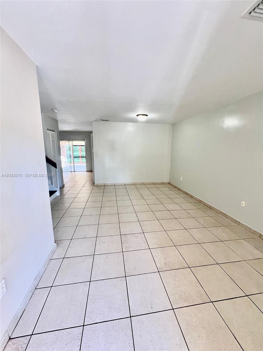 This room features light-colored tile flooring, white walls, and a sliding glass door — 6975 NW 173rd Dr # 2007, Hialeah FL 33015, HIALEAH, FL