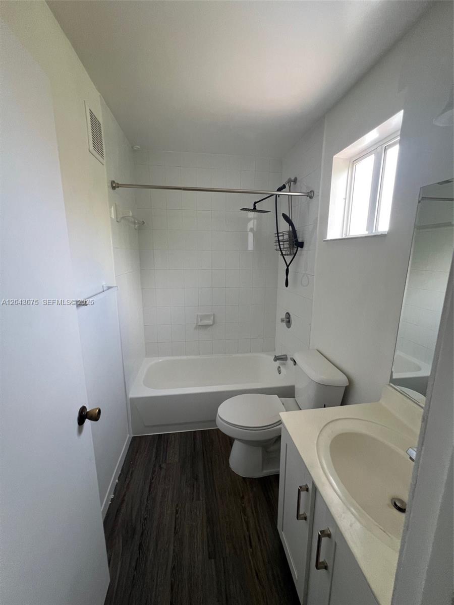A bathroom features a white tub-shower combo, a toilet, and a vanity with a mirror — 6975 NW 173rd Dr # 2007, Hialeah FL 33015, HIALEAH, FL