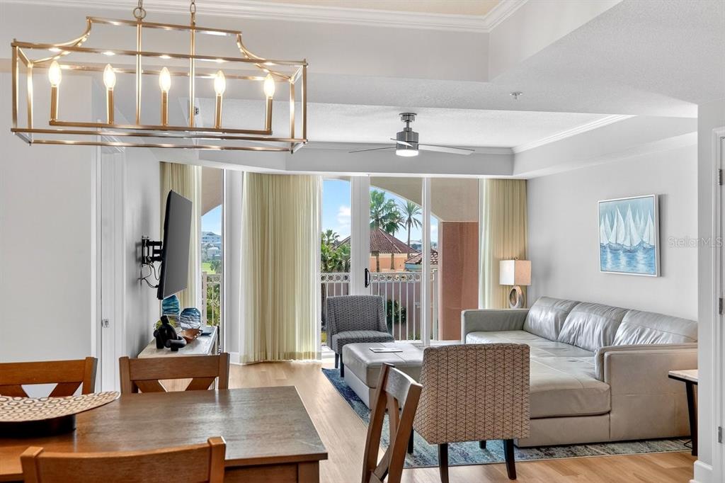 A living room with a dining area, a sectional sofa, and a balcony with palm trees — 200 OCEAN CREST DRIVE UNIT 217, PALM COAST, FL