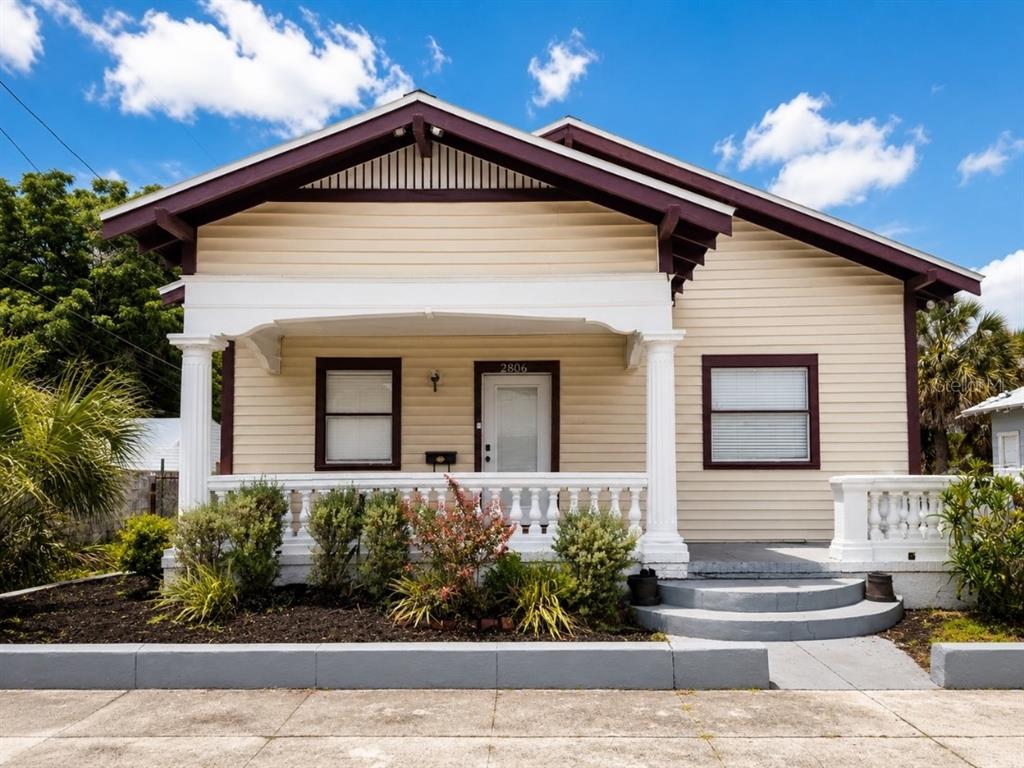 A single-story house with beige siding, a front porch, and a dark brown gabled roof — 2806 N 17TH STREET, TAMPA, FL