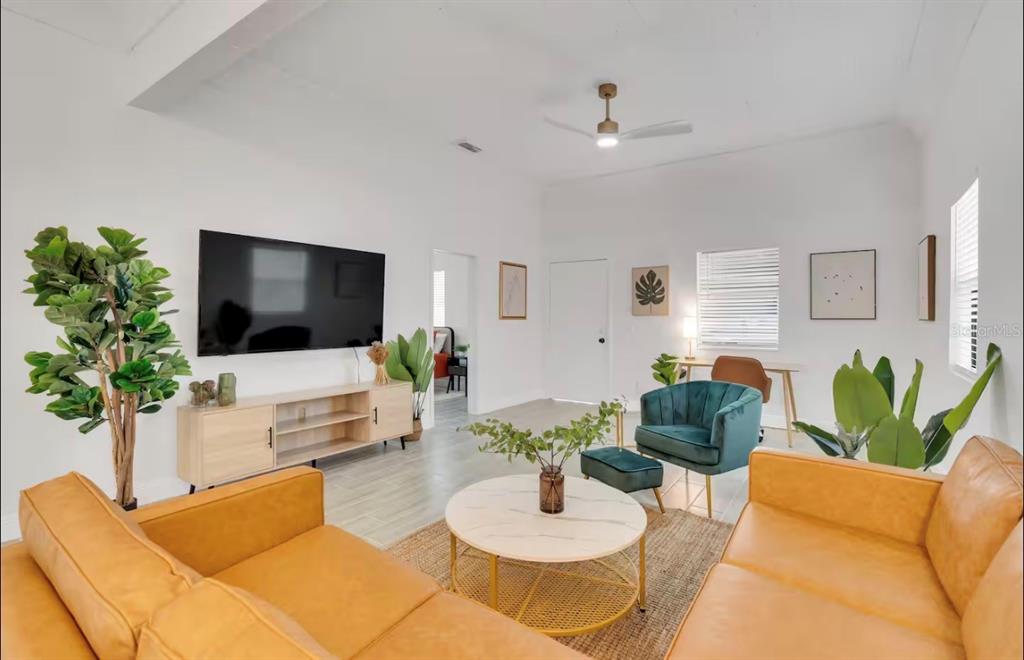 A living room features two tan leather sofas, a round coffee table, and a television — 2806 N 17TH STREET, TAMPA, FL