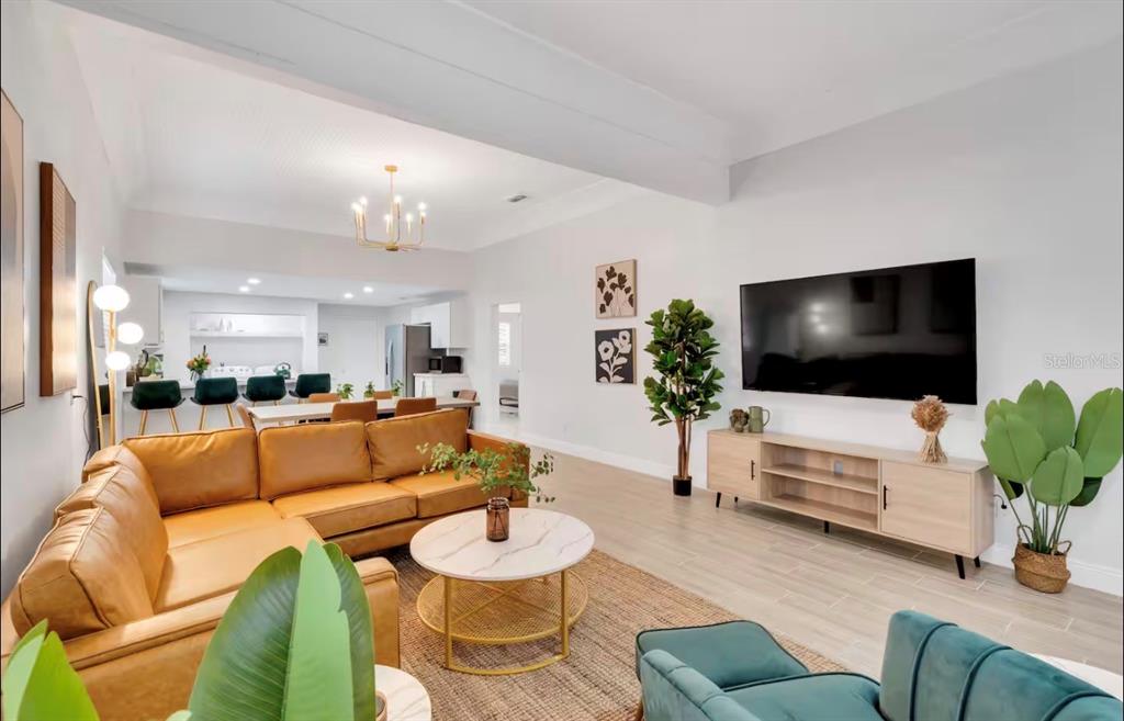 A living room with a tan sectional sofa, marble coffee table, and wall-mounted television — 2806 N 17TH STREET, TAMPA, FL