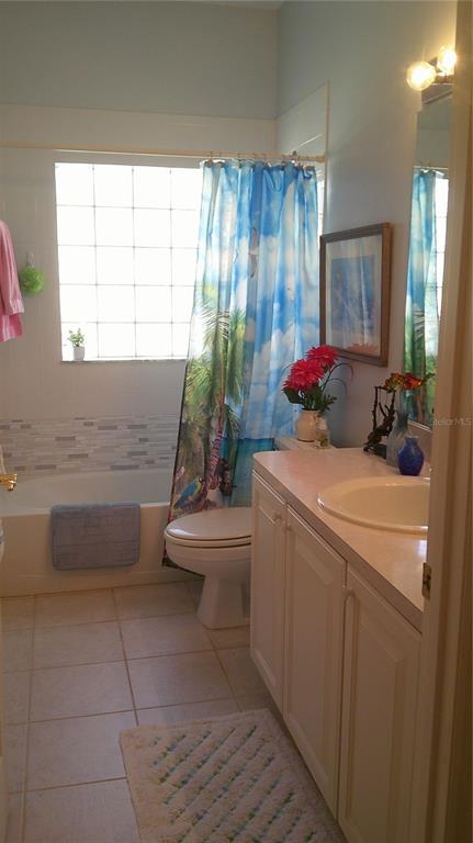 A bathroom features a tiled floor, a vanity with a sink, and a glass-block window — 1640 PALACE COURT, PUNTA GORDA, FL