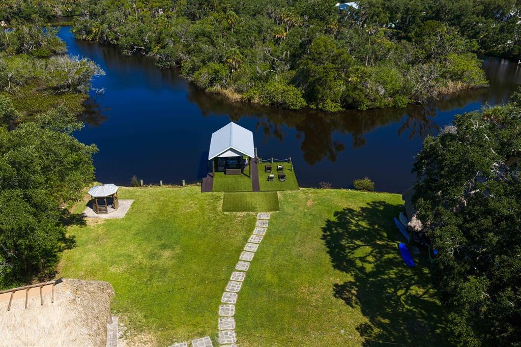 An aerial view of a grassy backyard leading to a boat dock on a river — 1030 MILL CREEK ROAD, BRADENTON, FL