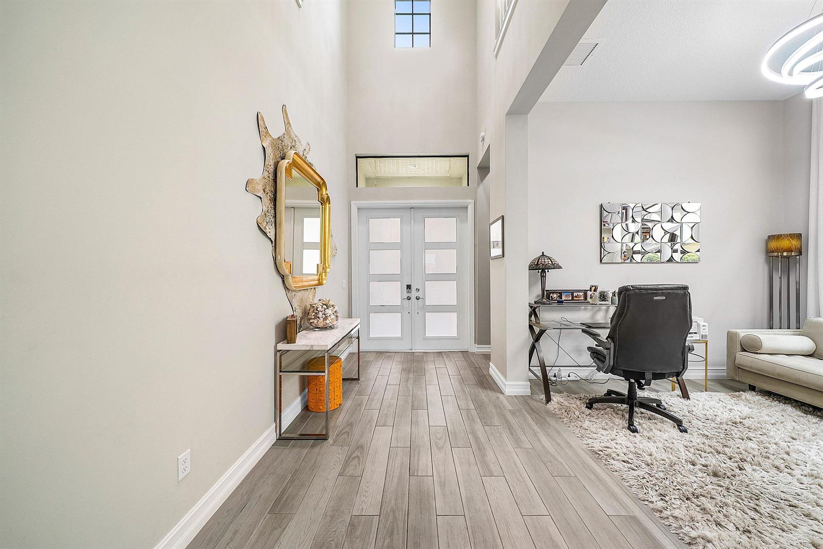 An open-concept kitchen and dining area features dark wood cabinetry, a stone-tiled island, and stairs — 8884 Grand Prix Lane, Boynton Beach FL 33472, BOYNTON BEACH, FL