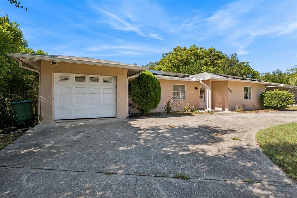 A single-story house with a beige exterior, a one-car garage, and a concrete driveway — 1539 FORT SMITH BOULEVARD, DELTONA, FL