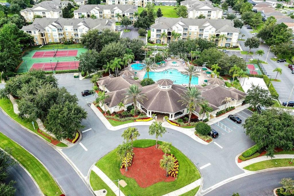 An aerial view of an apartment complex featuring a clubhouse, swimming pool, and tennis courts — 2307 BUTTERFLY PALM WAY UNIT 102, KISSIMMEE, FL