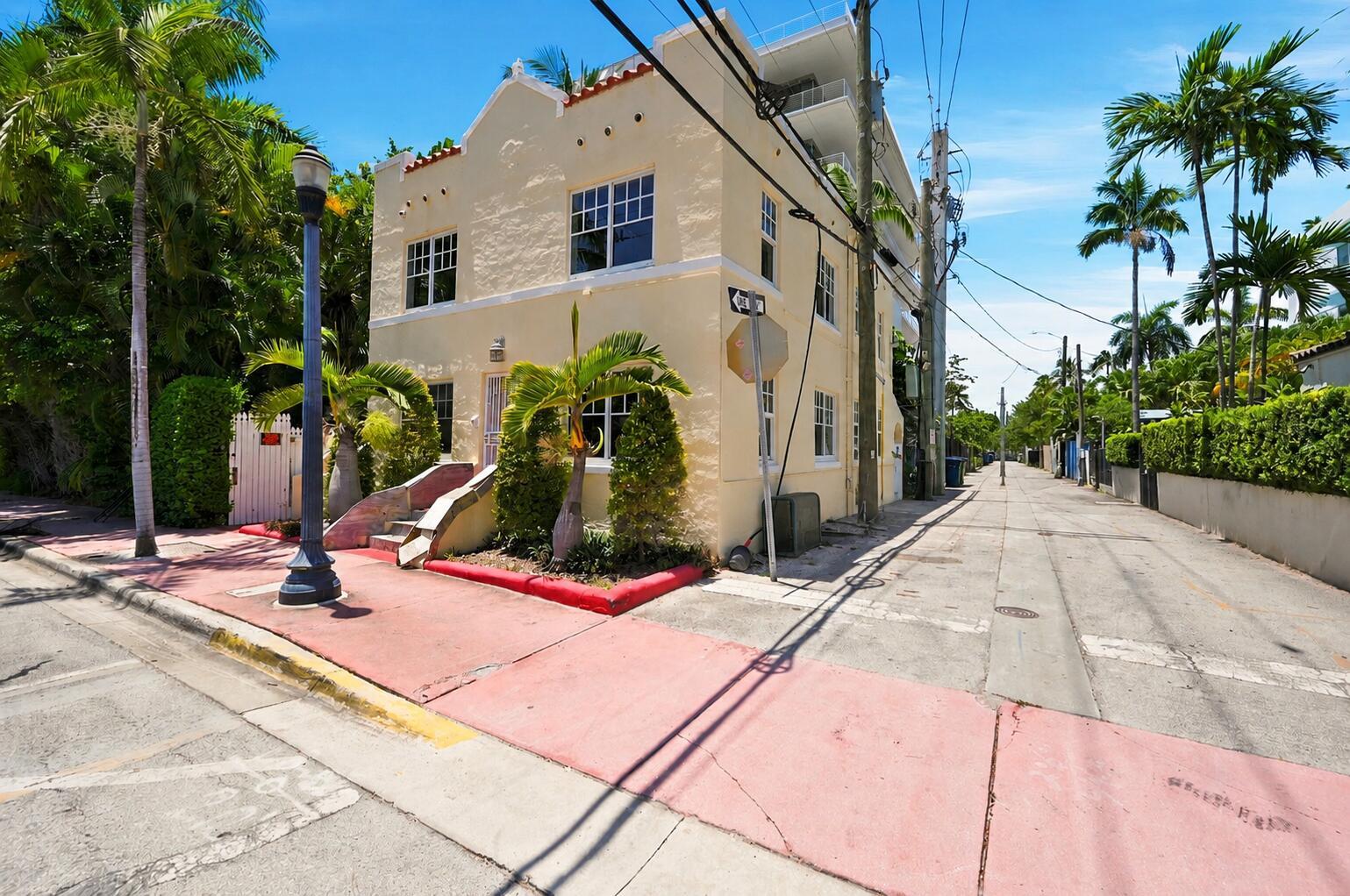 A two-story yellow stucco building stands on a corner lot with palm trees and sidewalks — 927 SW 4th Street, Miami FL 33130, MIAMI, FL