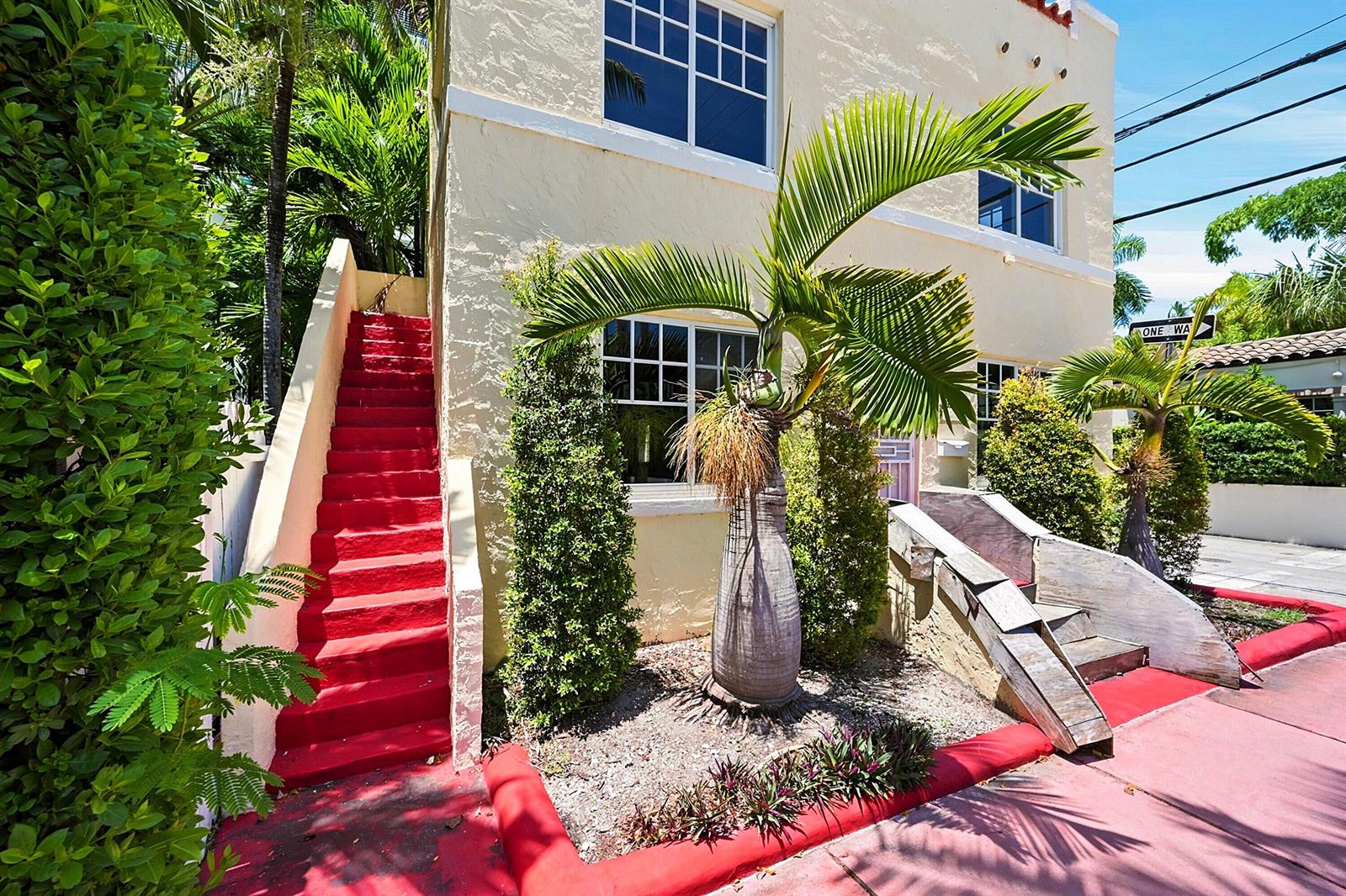 A yellow two-story building features a bright red exterior staircase and a palm tree — 927 SW 4th Street, Miami FL 33130, MIAMI, FL