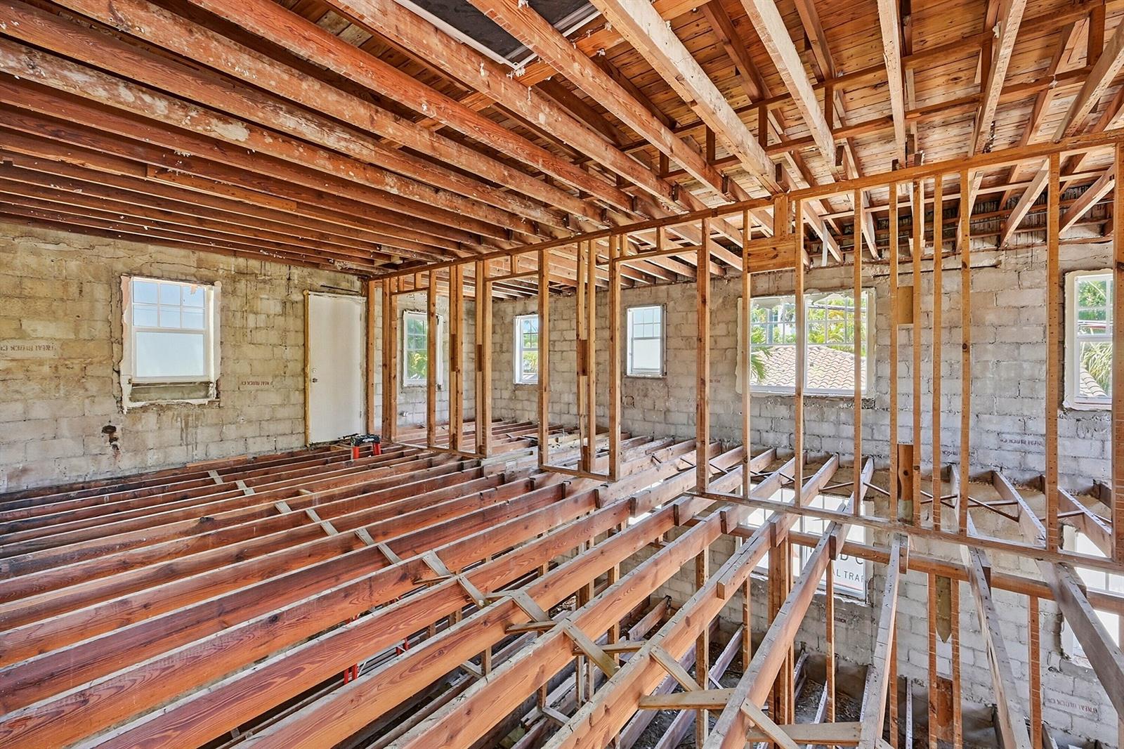 An interior view of a room under construction with exposed wooden ceiling joists and wall studs — 927 SW 4th Street, Miami FL 33130, MIAMI, FL