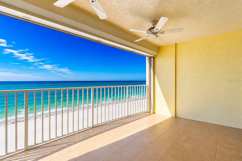 A covered balcony with tile flooring, a ceiling fan, and a view of the ocean — 16750 GULF BOULEVARD UNIT 414, NORTH REDINGTON BEACH, FL