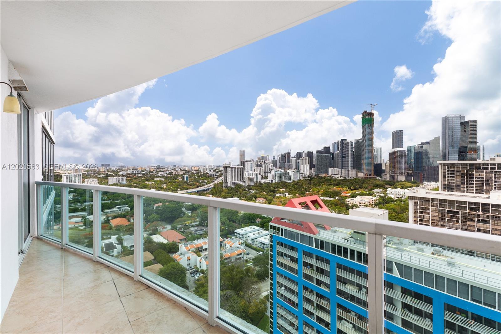 A balcony with a glass railing overlooks a city skyline and suburban landscape — 2101 NE Brickell Ave # 2302, Miami FL 33129, MIAMI, FL