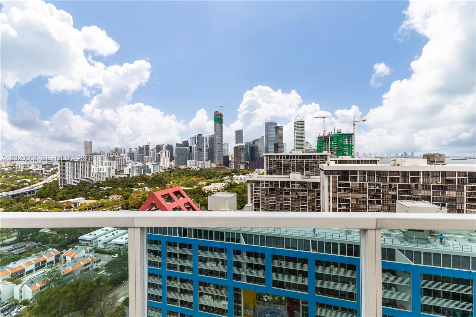A high-angle view shows a city skyline with skyscrapers and construction cranes from a balcony — 2101 NE Brickell Ave # 2302, Miami FL 33129, MIAMI, FL