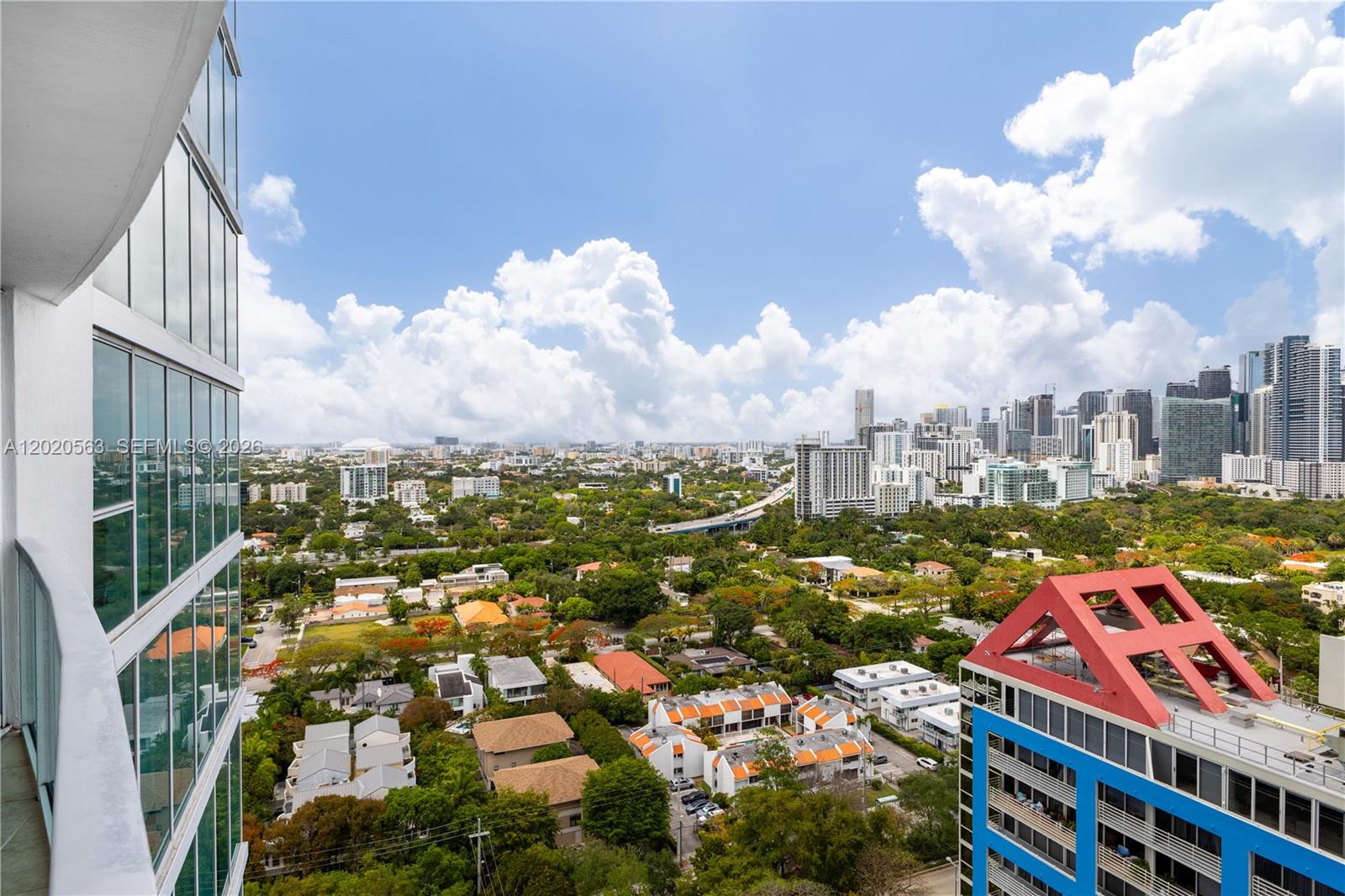 An elevated view of a city skyline with residential buildings and lush green trees — 2101 NE Brickell Ave # 2302, Miami FL 33129, MIAMI, FL