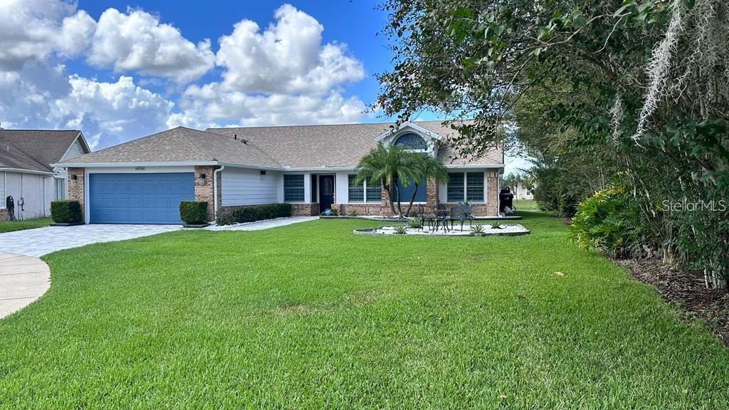 A single-story house with a blue garage door, a front lawn, and a palm tree — 14506 TIMUCUA COURT, ORLANDO, FL