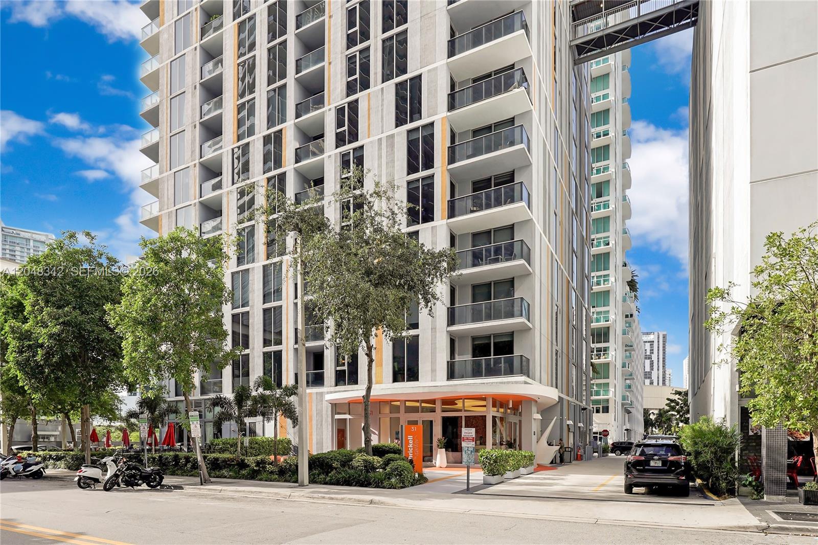 A modern high-rise apartment building features a glass-enclosed entrance and a pedestrian bridge connection — 31 SE 6th St # 2706, Miami FL 33131, MIAMI, FL