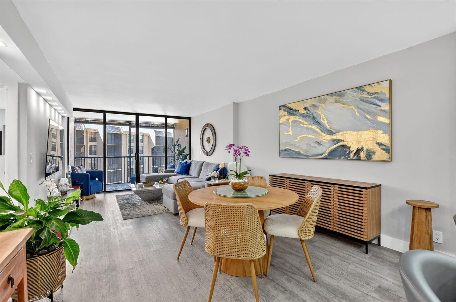 A living and dining room with light wood floors, a round table, and balcony access — 20 Royal Palm Way # 503, Boca Raton FL 33432, BOCA RATON, FL