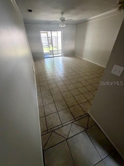 An empty room features light-colored tile flooring, a ceiling fan, and sliding glass patio doors — 300 KENT PLACE, SAFETY HARBOR, FL