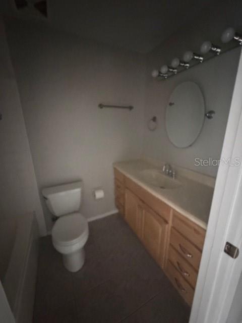 A bathroom features a wooden vanity with a sink, a toilet, and an oval mirror — 300 KENT PLACE, SAFETY HARBOR, FL