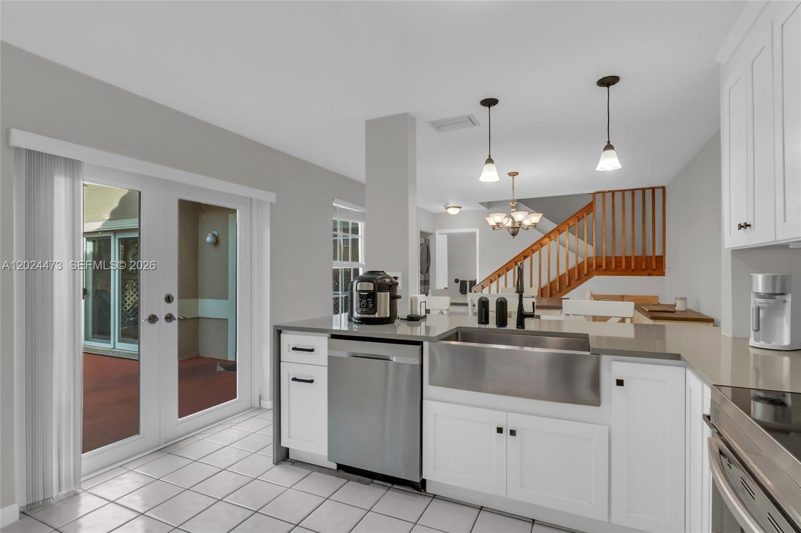 A kitchen features white cabinets, a stainless steel farmhouse sink, and a tiled floor — 11022 Chandler Dr, Cooper City FL 33026, COOPER CITY, FL