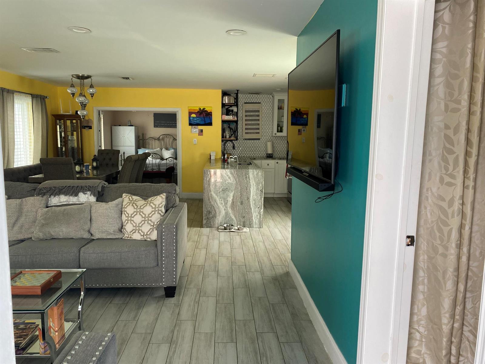 A living room with a gray sofa leads to a kitchen featuring a stone island — 416 N D Street # 2, FL 33460, FL