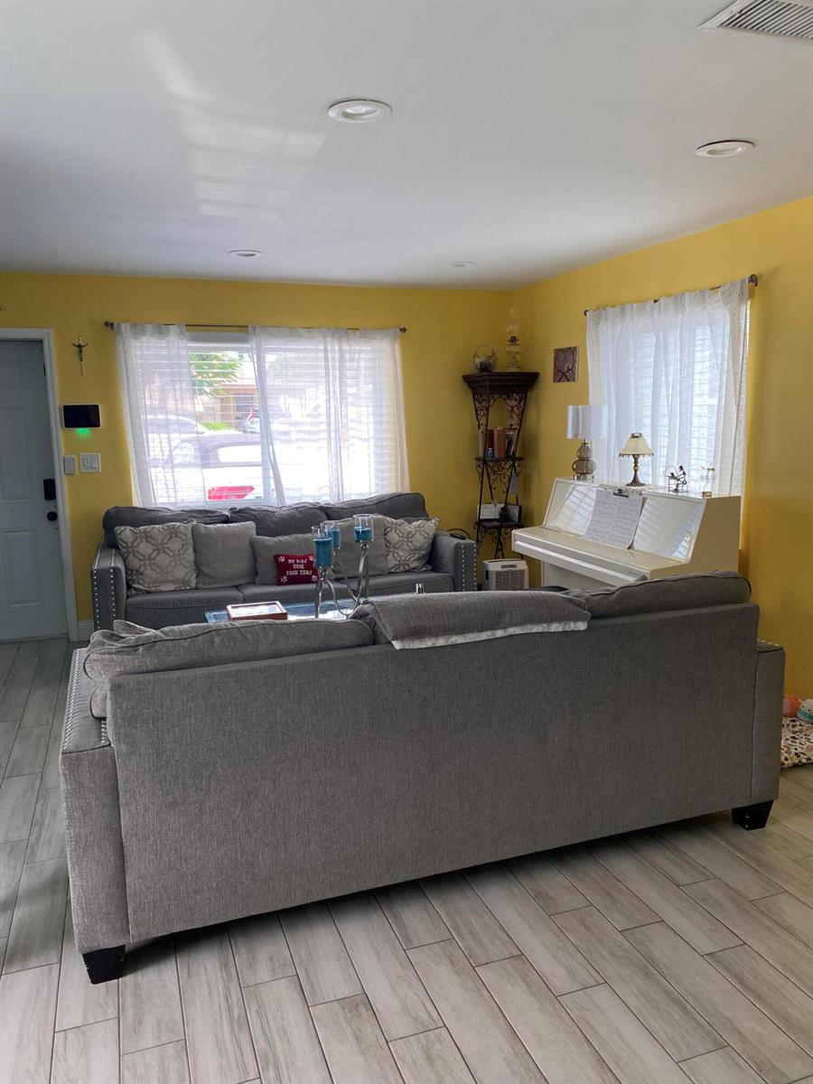 A living room features two gray sofas, a white piano, and yellow walls — 416 N D Street # 2, FL 33460, FL