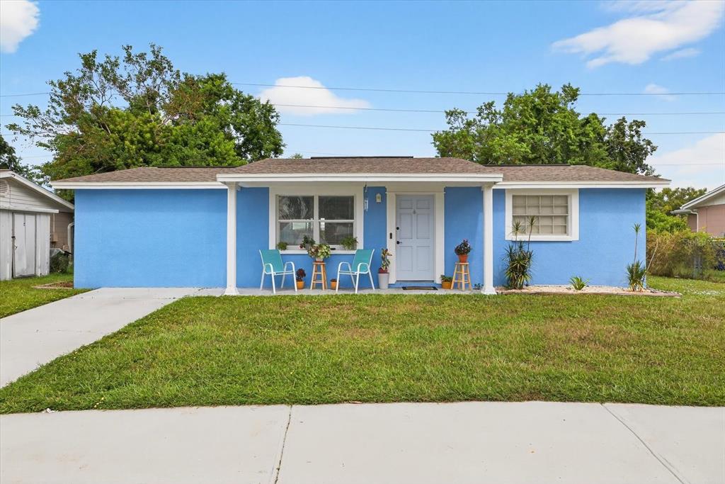 A bright blue single-story house with a front porch and a concrete driveway — 7811 FOX HOLLOW DRIVE, PORT RICHEY, FL