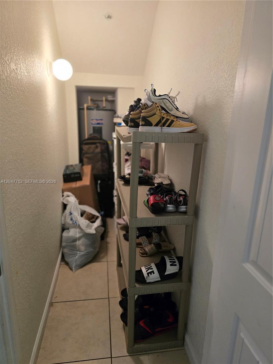 A narrow storage closet contains a plastic shelving unit filled with various pairs of shoes — 146 SW 7th Ct, Pompano Beach FL 33060, POMPANO BEACH, FL