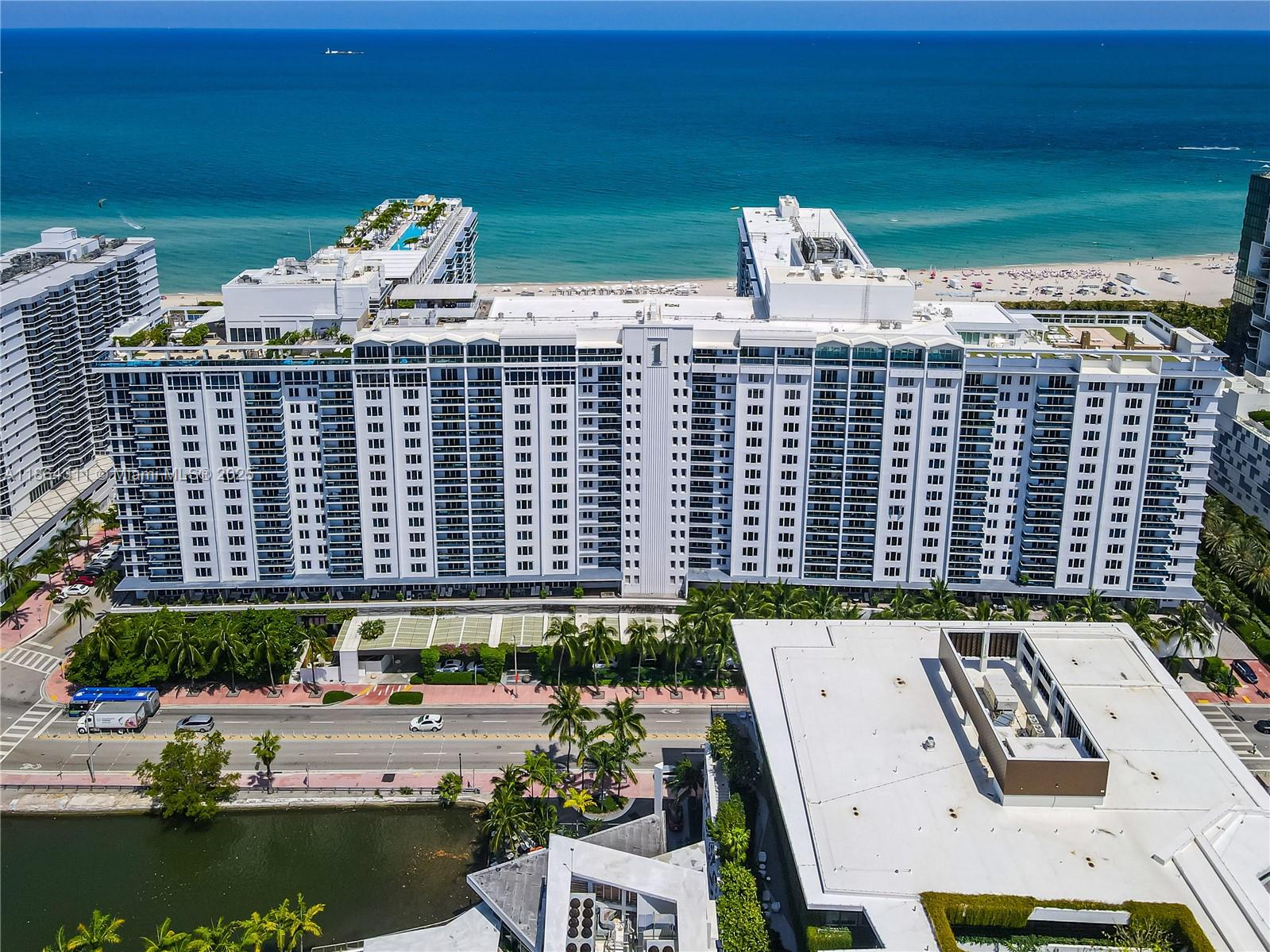 An aerial view shows a large white beachfront hotel complex with a pool deck — 2301 Collins Ave # 542, Miami Beach FL 33139, MIAMI BEACH, FL