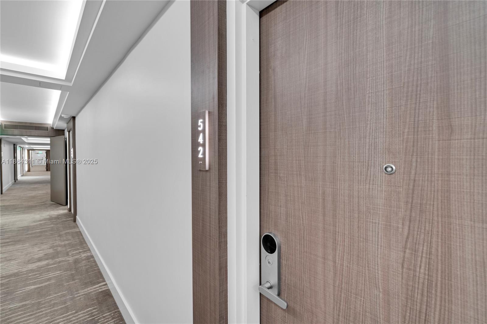 A hallway view shows a wooden door with a digital lock and room number 542 — 2301 Collins Ave # 542, Miami Beach FL 33139, MIAMI BEACH, FL