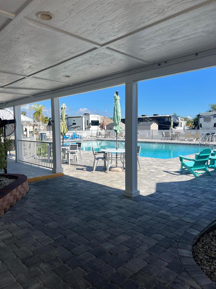 A covered patio overlooks a swimming pool surrounded by lounge chairs and RVs — 7950 Florida 78, Okeechobee FL 34974, OKEECHOBEE, FL