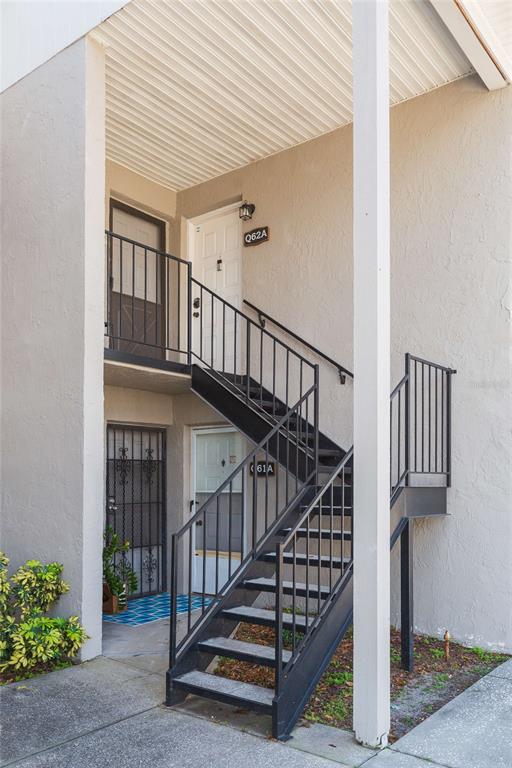 An exterior view shows a two-story apartment building with metal stairs leading to an upper unit — 4513 S OAK DRIVE UNIT Q62A, TAMPA, FL