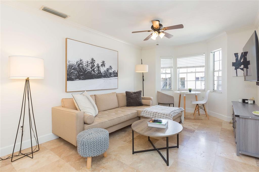 A living room features a beige sectional sofa, a round coffee table, and tile flooring — 4513 S OAK DRIVE UNIT Q62A, TAMPA, FL