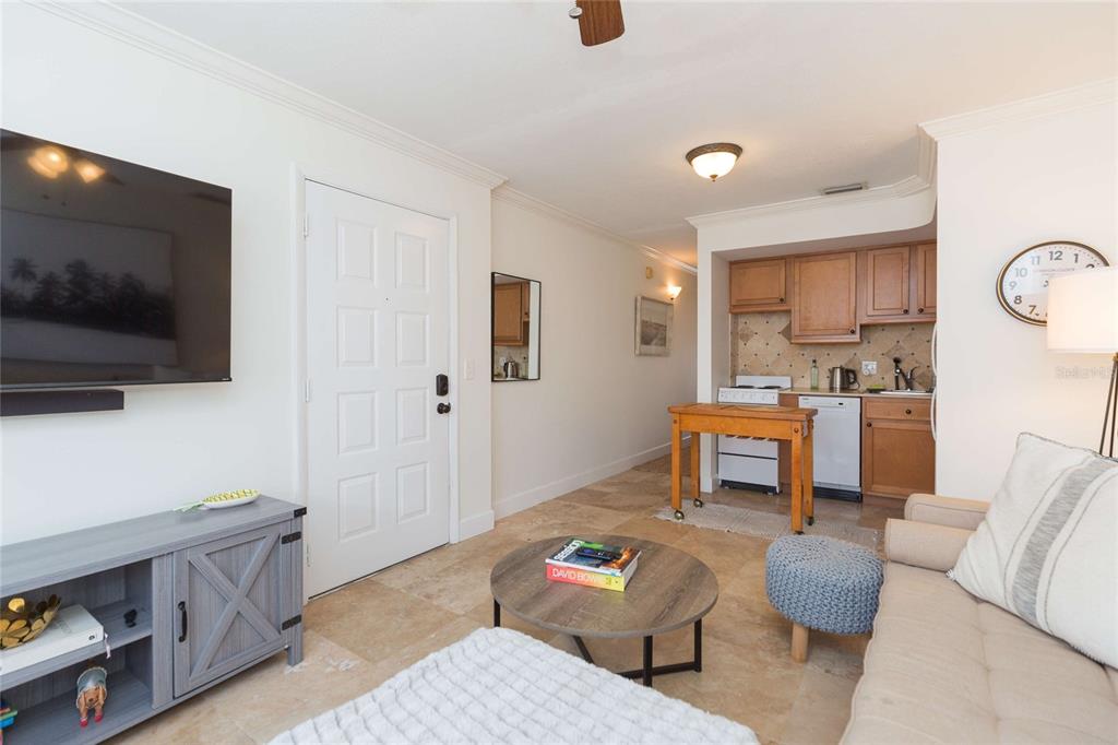 A living room with a kitchenette, tile floors, a television, and a sofa — 4513 S OAK DRIVE UNIT Q62A, TAMPA, FL
