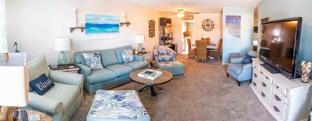 A living room with a blue sofa, armchairs, a coffee table, and a television console — 3018 59TH STREET S UNIT 309, GULFPORT, FL