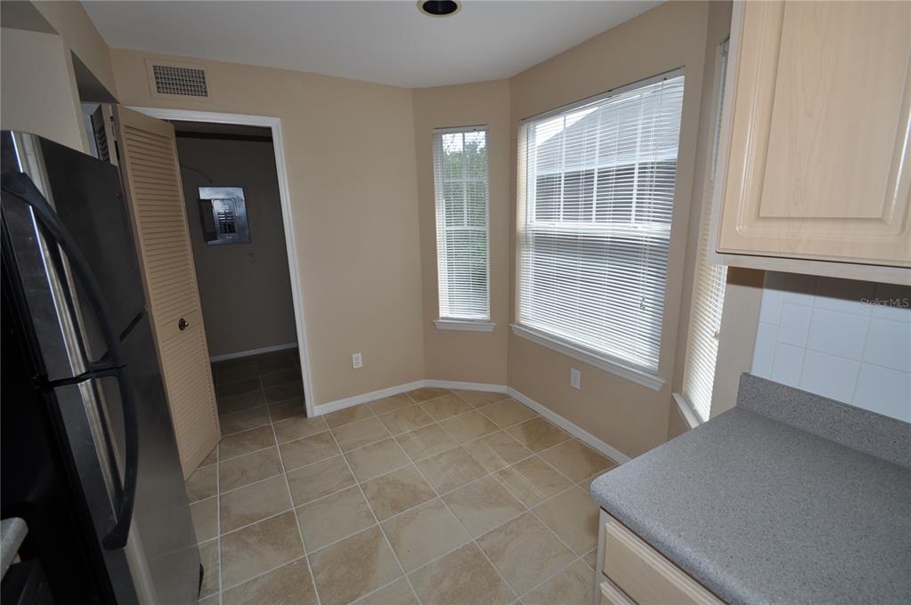 A kitchen breakfast nook with tile flooring, beige walls, and windows with white blinds — 408 SUMMIT RIDGE PLACE UNIT 316, LONGWOOD, FL