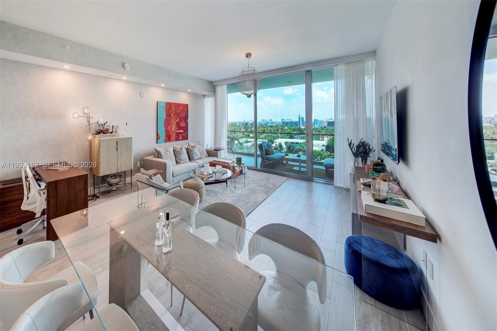 A modern living and dining room with floor-to-ceiling windows overlooking a balcony and city view — 10201 Collins Ave # 804, Bal Harbour FL 33154, BAL HARBOUR, FL