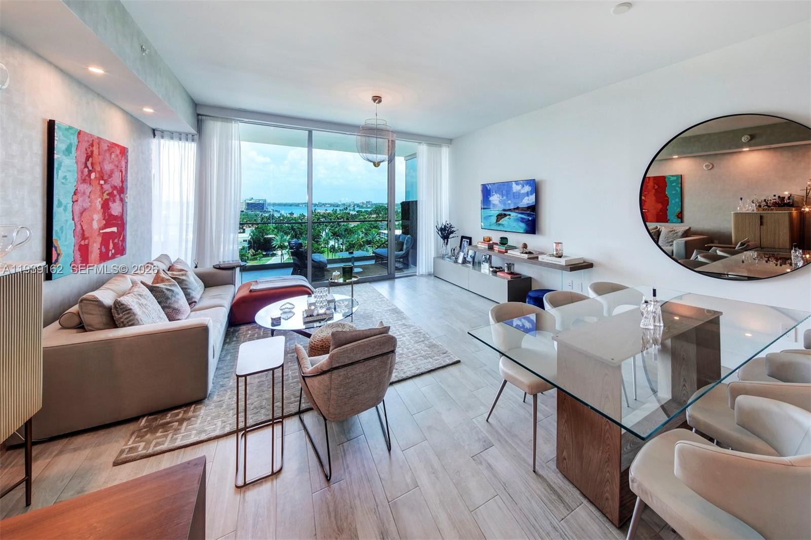 A modern living and dining area features floor-to-ceiling windows with a balcony and water view — 10201 Collins Ave # 804, Bal Harbour FL 33154, BAL HARBOUR, FL