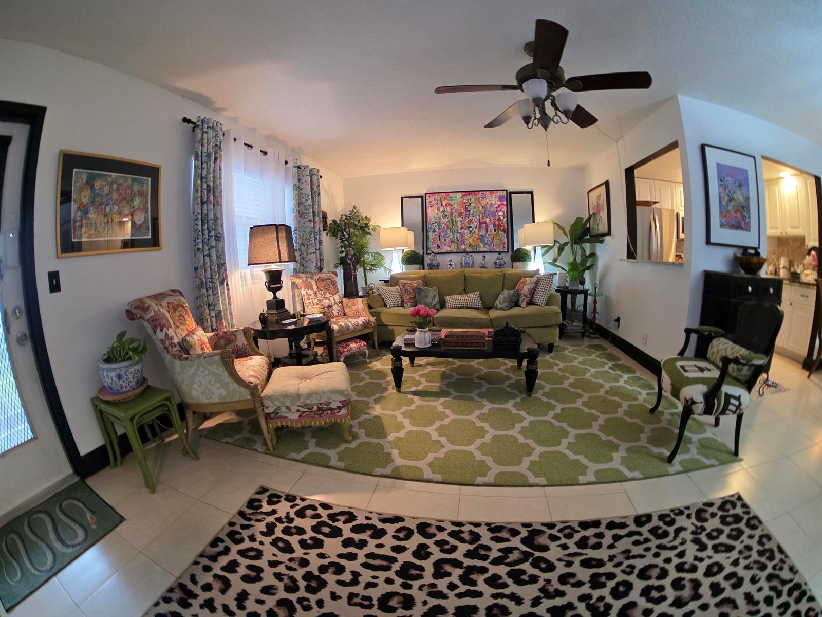 A living room features a green patterned rug, olive sofa, patterned armchairs, and a ceiling fan — 491 Brittany K, Delray Beach FL 33446, DELRAY BEACH, FL