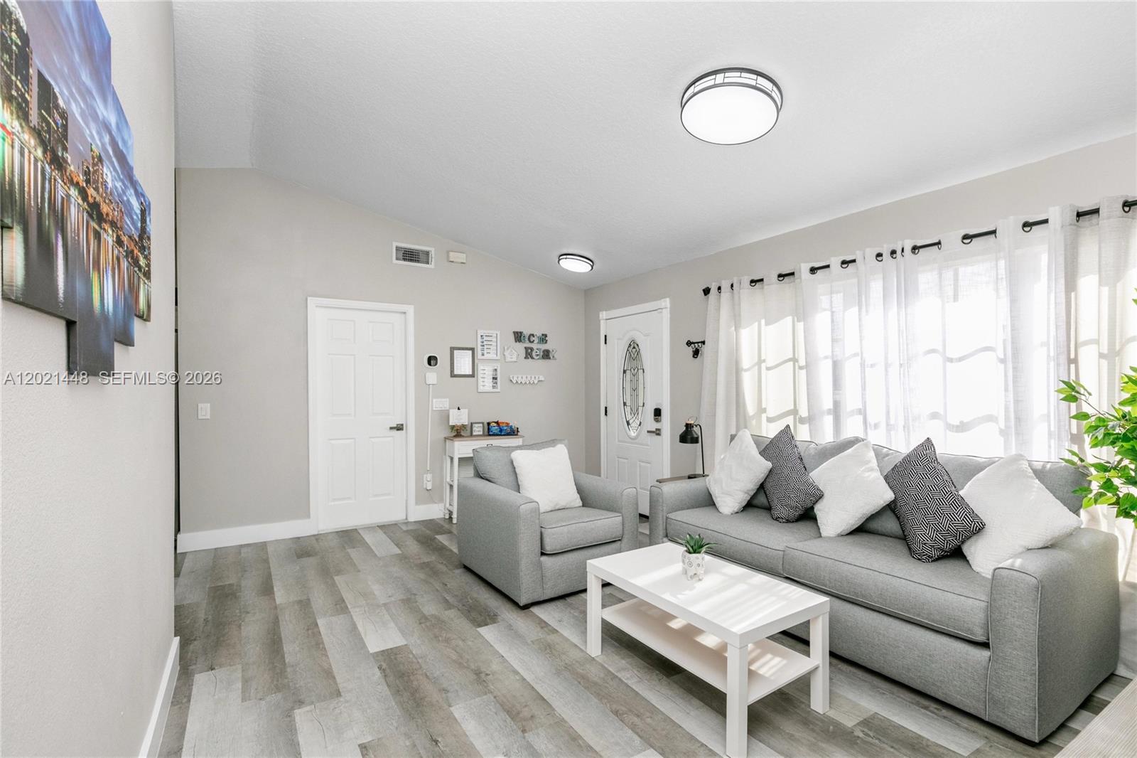 A living room features gray flooring, a gray sofa, an armchair, and a white coffee table — 5608 Mandarin, Davenport FL 33986, DAVENPORT, FL