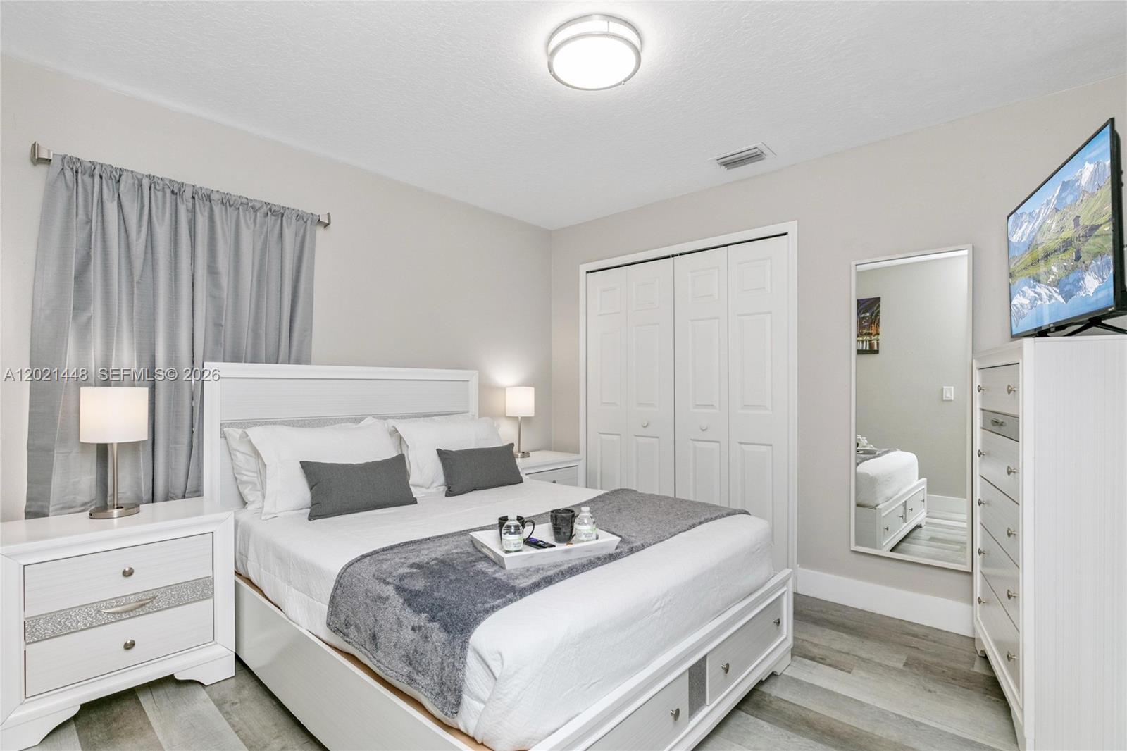 A bedroom features a white bed, matching furniture, gray curtains, and a wall-mounted television — 5608 Mandarin, Davenport FL 33986, DAVENPORT, FL