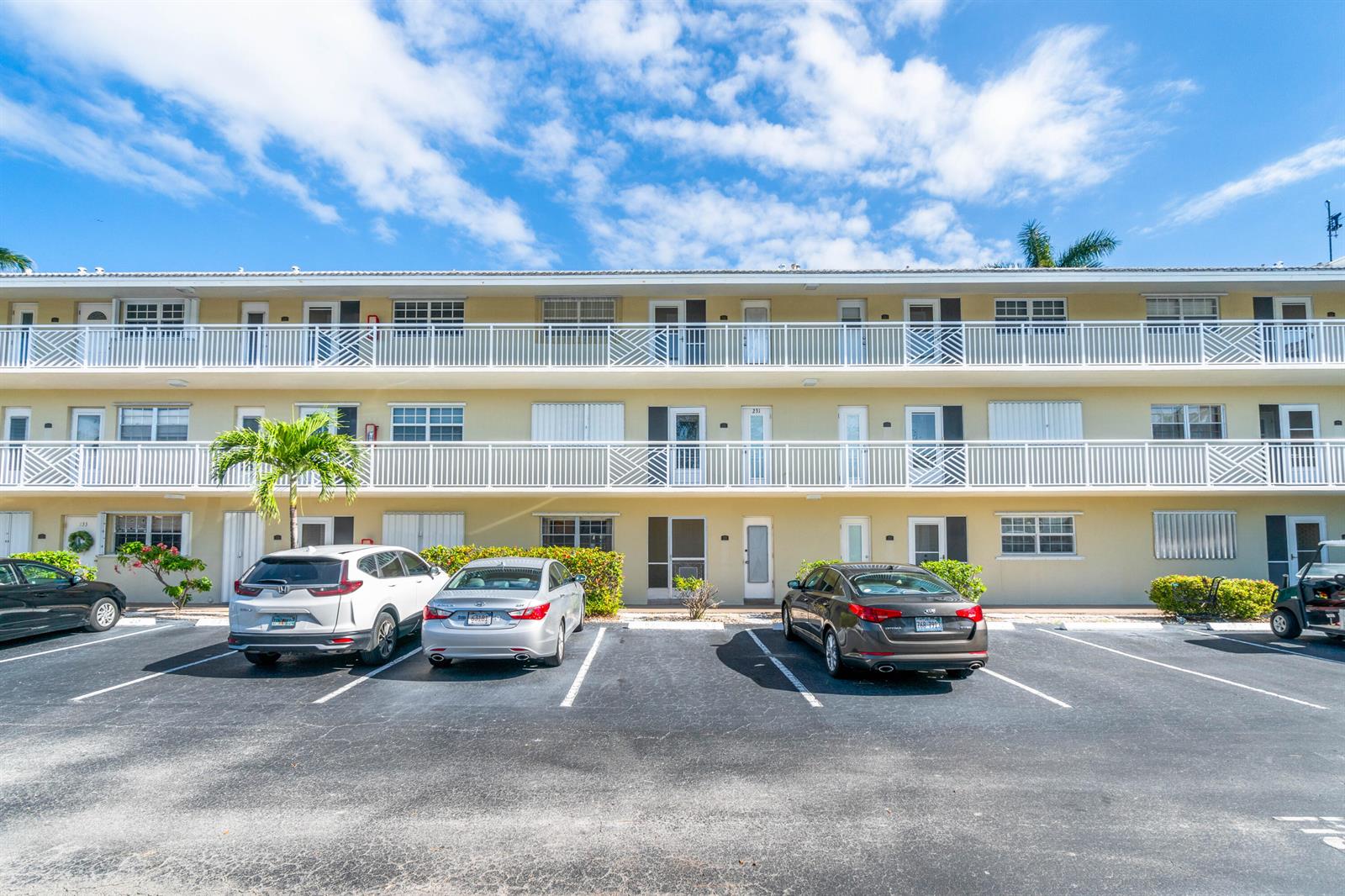 A three-story apartment building with white balconies and a parking lot in front — 1951 NE 39th Street # 131, Lighthouse Point FL 33064, LIGHTHOUSE POINT, FL
