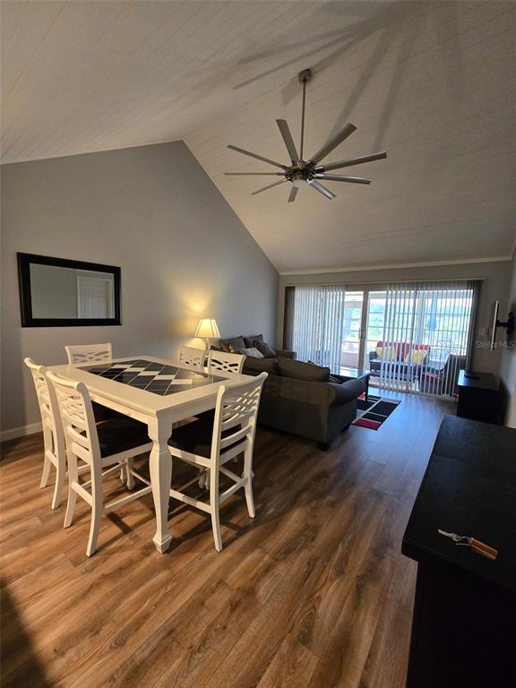 A dining area with a white table and chairs sits in an open-concept living room — 1118 VILLA LANE UNIT S, APOPKA, FL