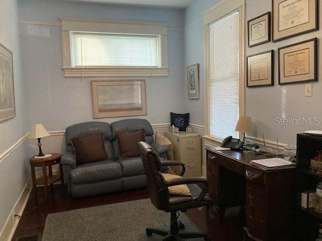 A home office features a blue loveseat, a wooden desk with a chair, and framed wall art — 806 W DE LEON STREET, TAMPA, FL