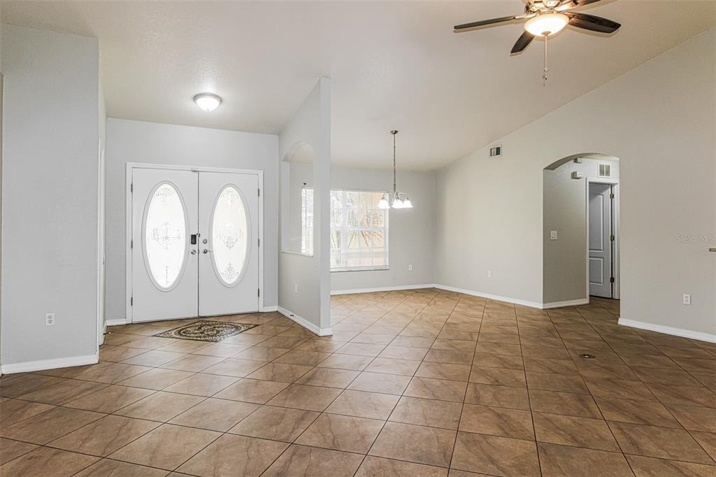 An entryway and dining area with light gray walls, tile flooring, and a ceiling fan — 6410 JAMAICA ROAD, SPRING HILL, FL