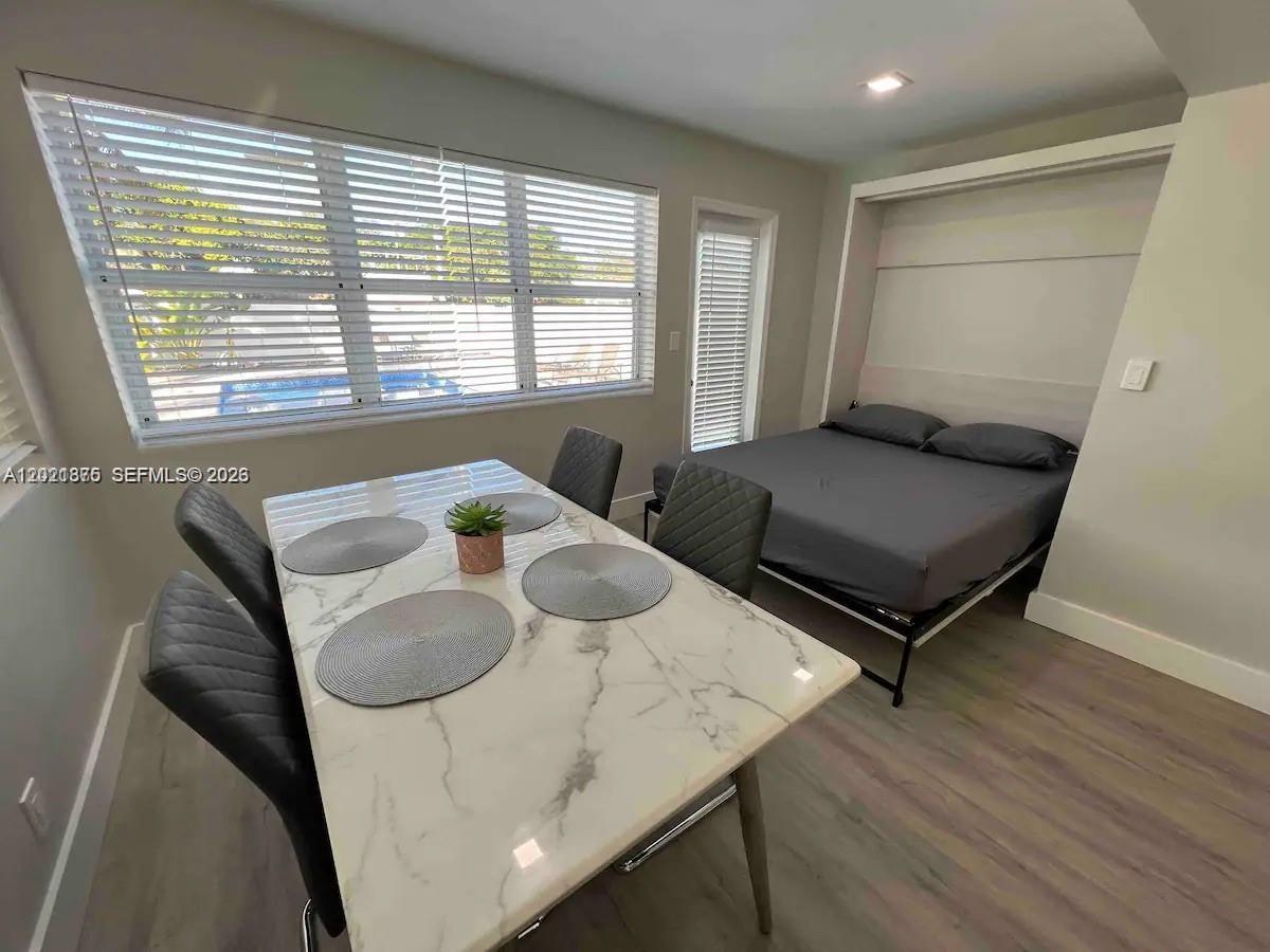 A room features a dining table with four chairs and a wall-mounted Murphy bed — 1925 Dewey St # 1925, Hollywood FL 33020, HOLLYWOOD, FL